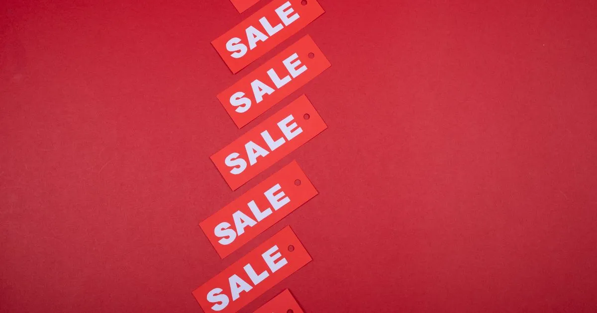 赤い背景の上に「SALE」と書かれた赤い値札が斜めに並んでいる様子