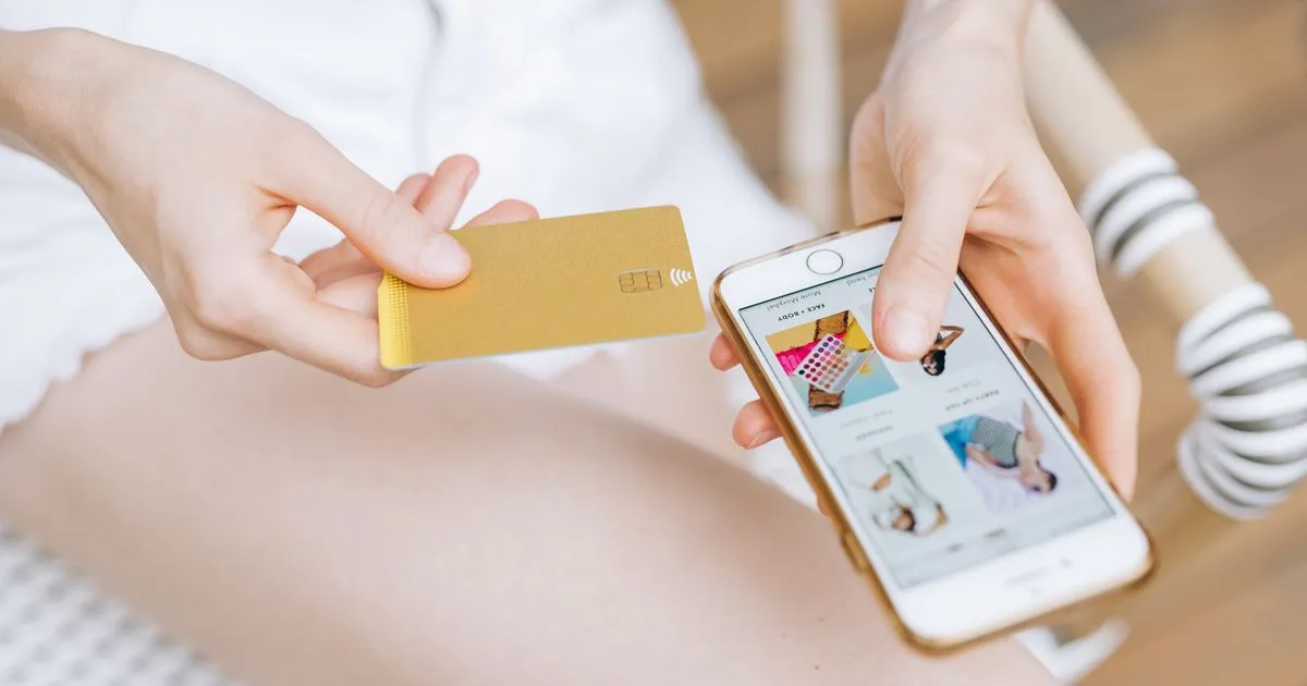 スマートフォンでオンライン購入の手続きをしている手元