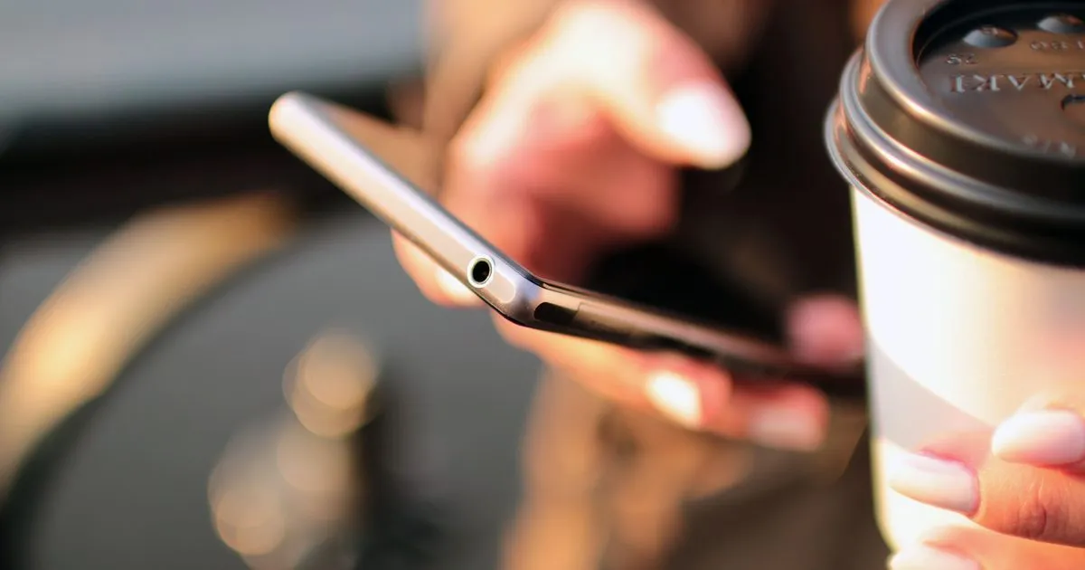 スマートフォンでメッセージを確認している手元